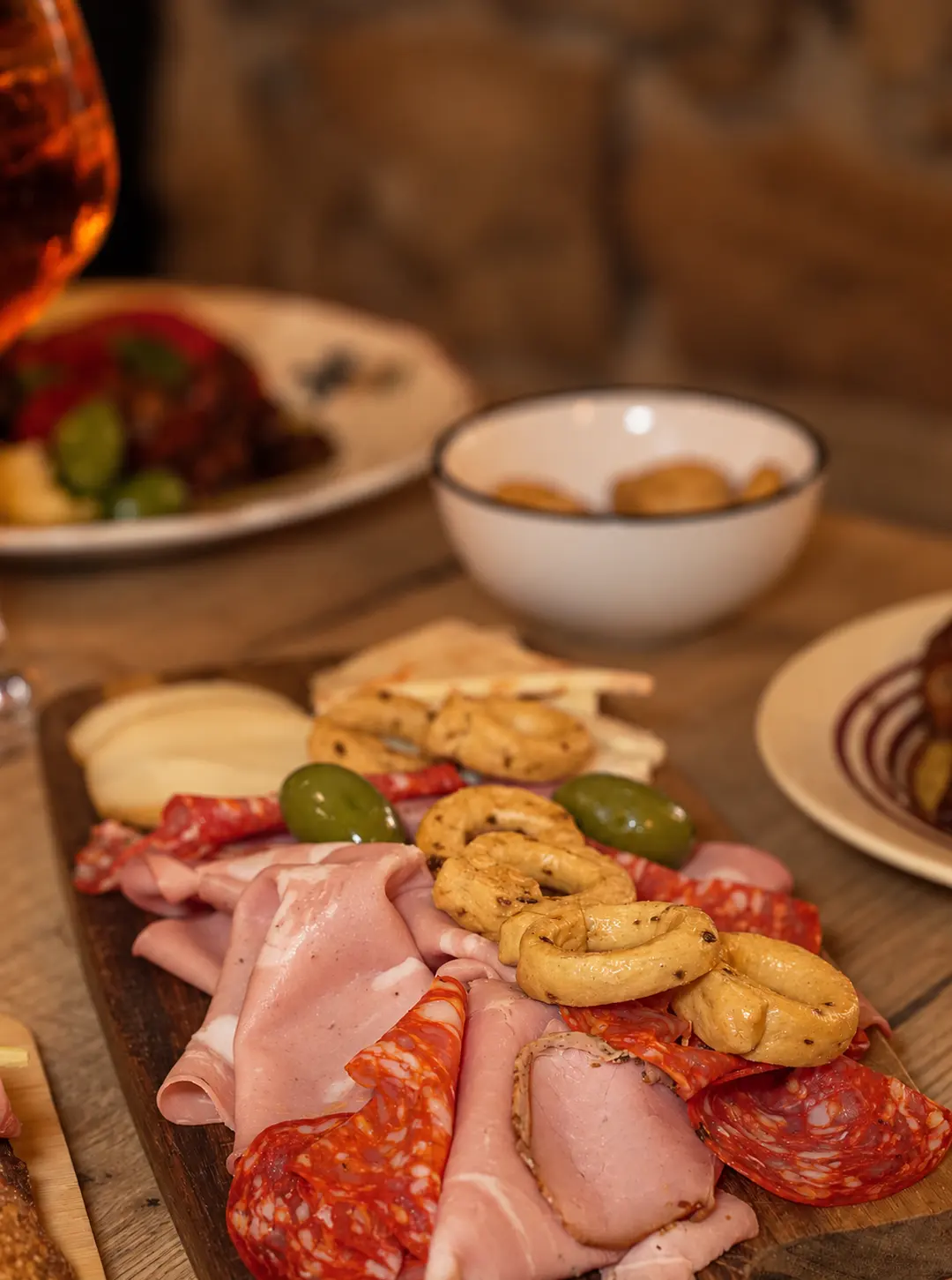 Une planche de charcuterie italienne, d'olives et de taralli.