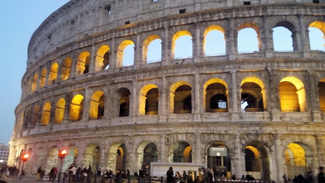 Un amphithéâtre antique illuminé à la tombée du jour, en Italie.