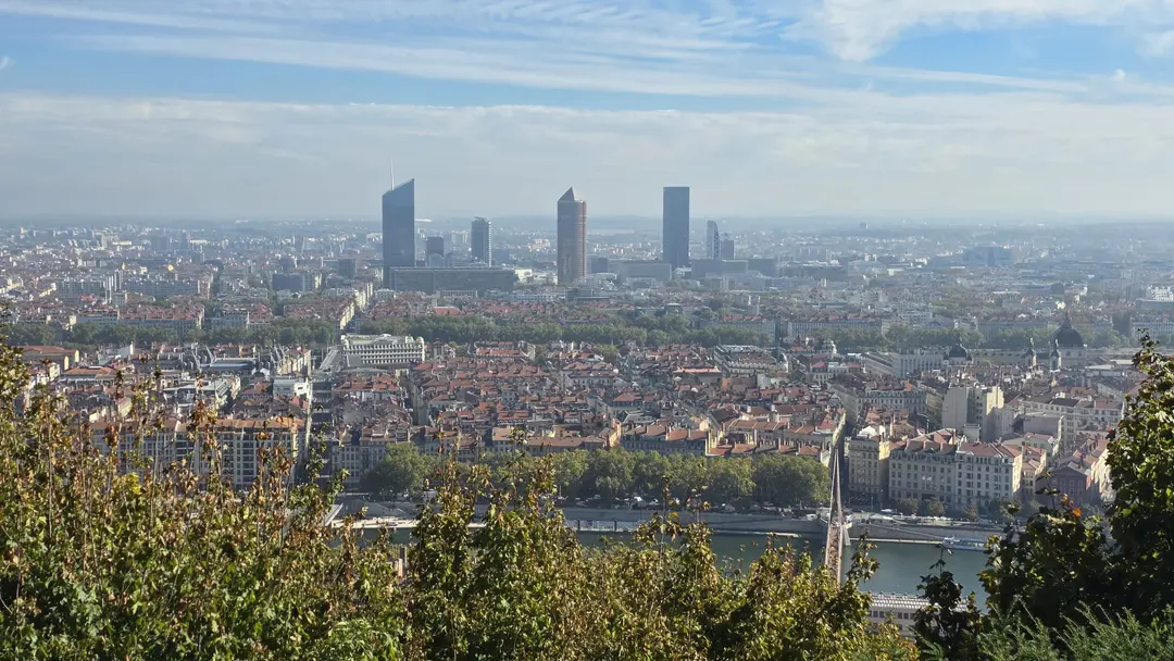 Lyon vue d'en haut, ses toits et ses tours sous un ciel clair.