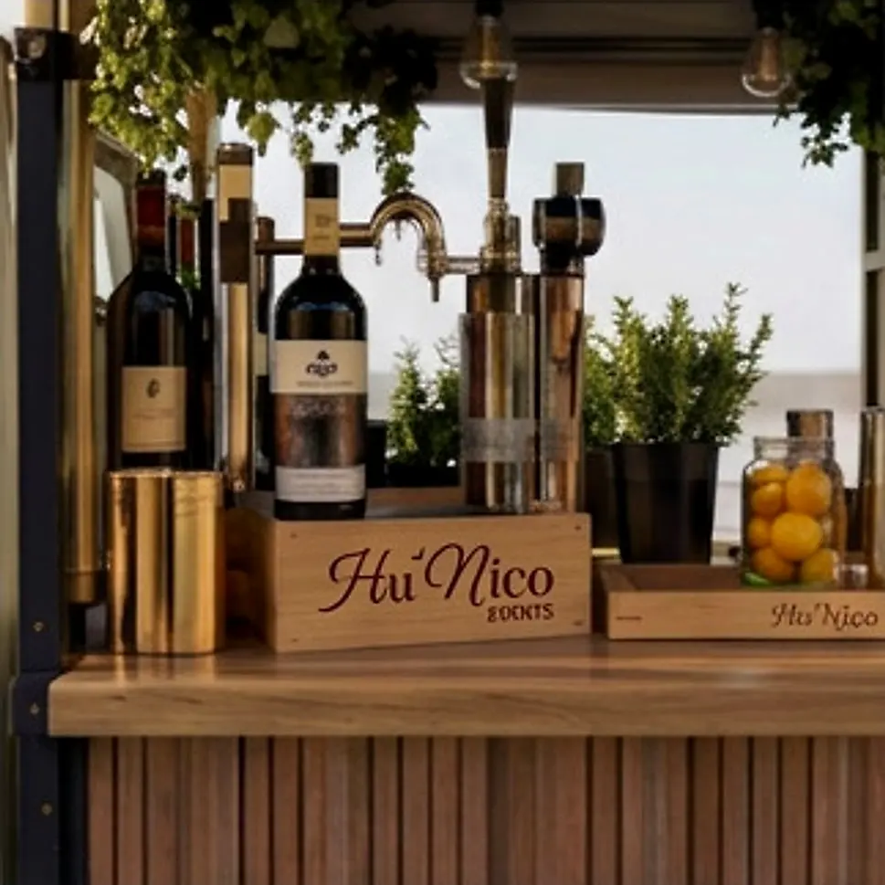 Le bar du Piaggio : bouteilles, tireuse et caisse en bois au logo de la Maison.