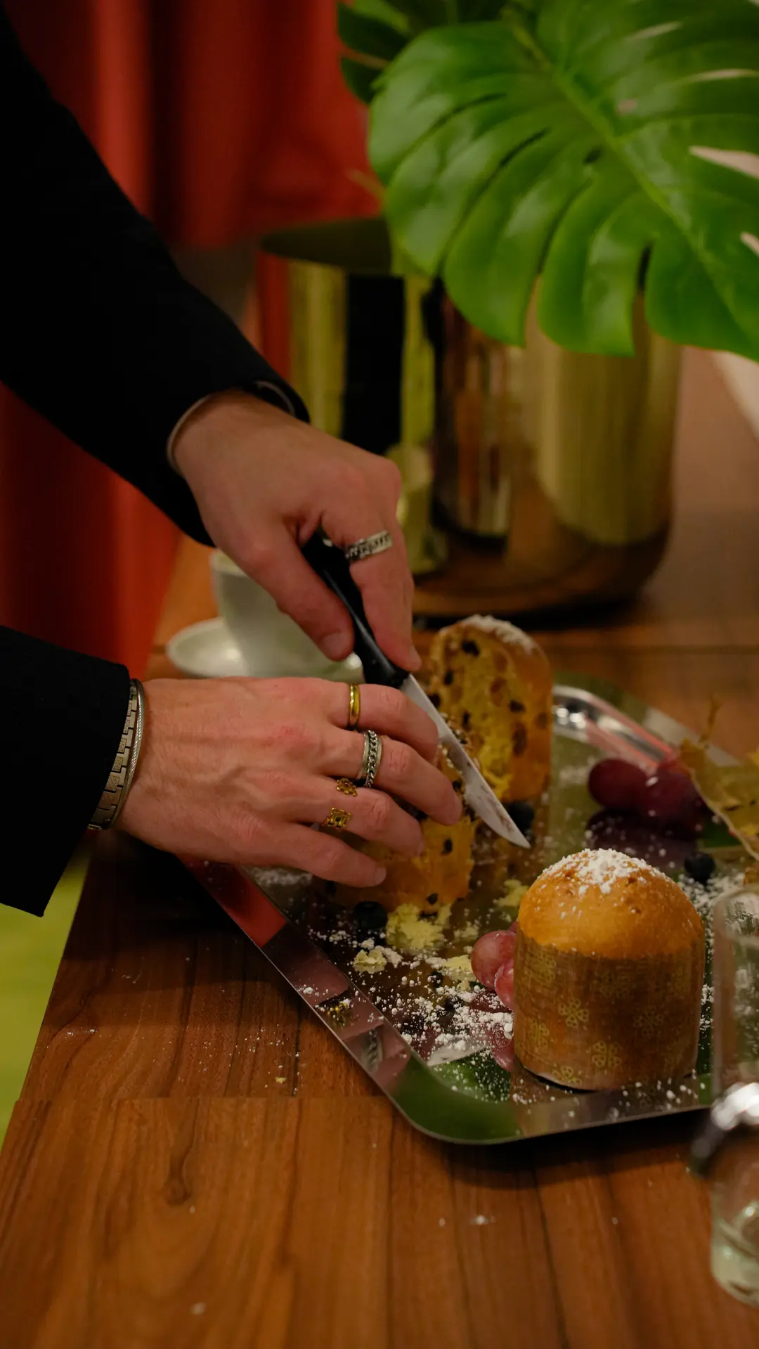 Des mains coupent une brioche sur un plateau de pause-café.